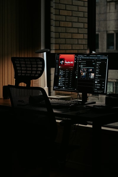 black flat screen computer monitor on black wooden desk